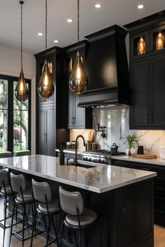 Reflective teardrop glass pendant lights over a luxurious kitchen island with dark cabinetry. White Cabinets With Black Island Kitchen, Kitchen Decor Ideas Black And White, Kitchen Ideas With Black Cabinets, Kitchen Island Ideas Black, Traditional Black Kitchen, Black Kitchen Ideas Modern, Kitchen Ideas Black Countertops, Pendant Lights Over Kitchen Island 2022, Black Glass Pendant Light Kitchen