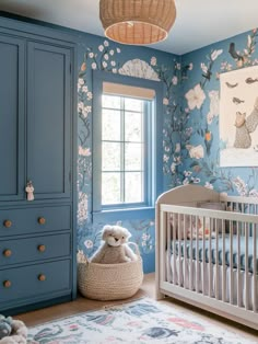 a baby's room with blue walls and floral wallpaper