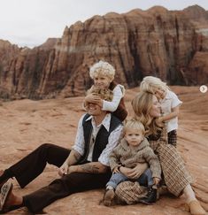 a group of people sitting on top of a desert