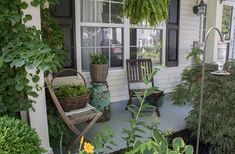 a porch with chairs and plants on it