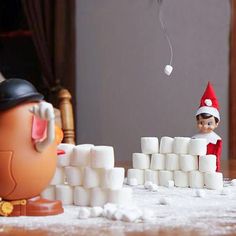 an elf is playing with marshmallows on the floor next to a pile of toilet paper