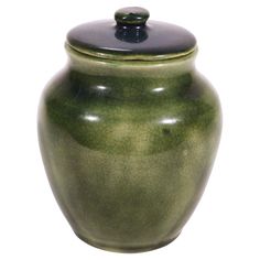 a green ceramic jar with a black lid