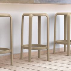 three stools are lined up against the wall