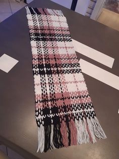 a pink and black scarf sitting on top of a table