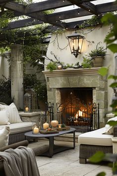 an outdoor living room with fireplace and couches