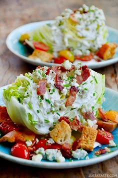 two white plates topped with lettuce and bacon salad