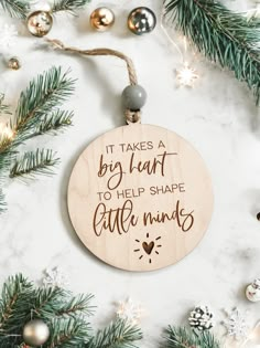 a wooden ornament that says it takes a big heart to help shape little minds