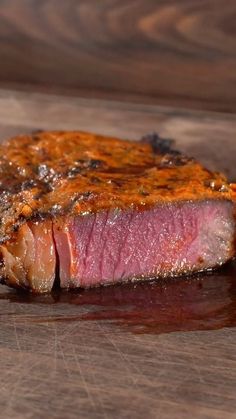 a piece of steak sitting on top of a wooden cutting board