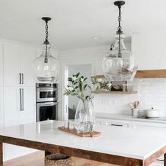 a kitchen with white counter tops and wooden floors