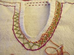 a close up of a piece of cloth with some scissors and thread on the table