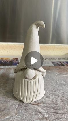 a clay figurine sitting on top of a wooden table