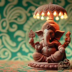 an elephant statue sitting under a lamp on top of a table