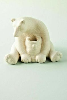 a white ceramic bear holding a baby cub