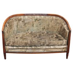 an old fashioned couch is upholstered with fabric and wood trimmings on the back