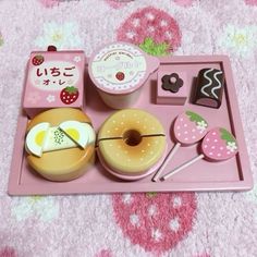 a pink tray with donuts and other items on it