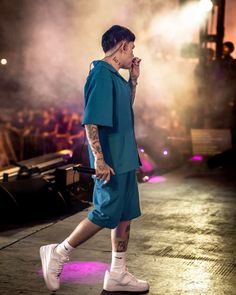 a man with tattoos walking on a stage