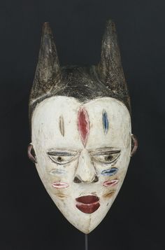 a white mask with horns on it's head and two different colored eyes in the middle