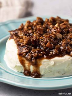 a piece of cake with pecans on top is sitting on a blue and white plate