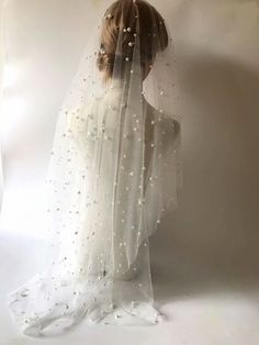 the back of a woman's head wearing a white veil with silver stars on it