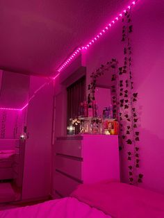 a bedroom with pink lights and decorations on the wall