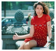 a woman in a red dress sitting on a bench