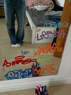 a person standing in front of a mirror with writing on it