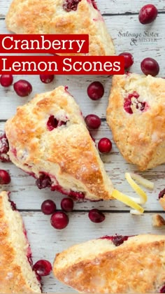 cranberry orange scones with lemon wedges on a white wooden surface surrounded by fresh cranberries