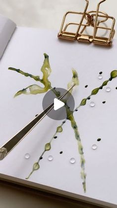 a close up of a book with scissors in it and water drops on the pages