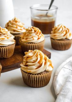 cupcakes with frosting and caramel on a cutting board