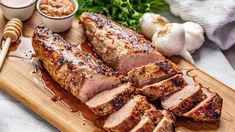 sliced pork on a cutting board with garlic and parsley