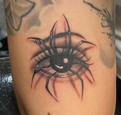 a close up of a spider tattoo on the leg