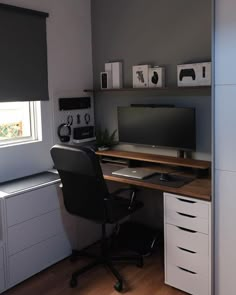 a desk with a monitor, keyboard and mouse on it in front of a window