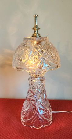 a clear glass table lamp on a red surface