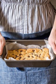 a person holding a pan filled with cookies