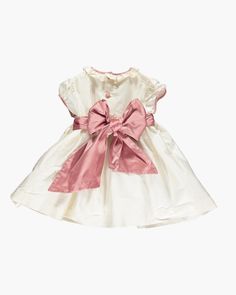 Exquisite, delicate and stunning looking 100% Dupioni silk celebration girl dress. Elegant ivory colour with subtle rose coloured details, delicately hand embroidered smock and silk covered buttons. The dress features puffed sleeves and three covered buttons at the back as well as a belt loop to keep the beautiful contrasting pink bow in place. The over-the-knee length skirt comes with a petticoat underneath to provide a voluminous and sophisticated look. The perfect dress to wear for any specia Silk Dress Pink, Hand Smocked Dress, Ivory Colour, Pink Silk Dress, Baby Boy Shirts, Girls Special Occasion Dresses, Dupioni Silk, Christening Gowns, Dress Gift