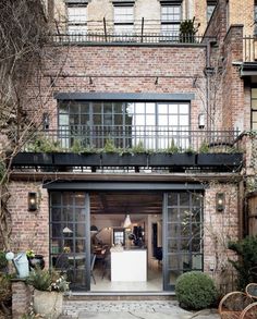 an apartment building with lots of windows and plants