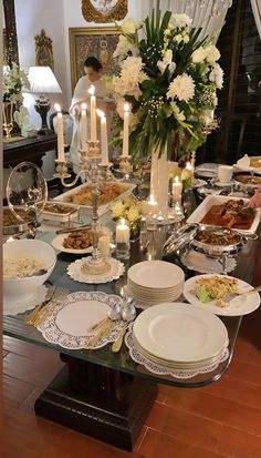 a long table with many plates and candles on it