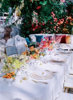 the table is set with white plates and place settings