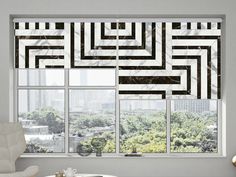 a living room filled with furniture next to a window covered in black and white squares