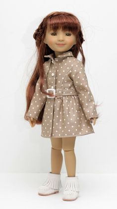 a doll with long red hair wearing a brown dress and white polka dot shoes, standing in front of a white background