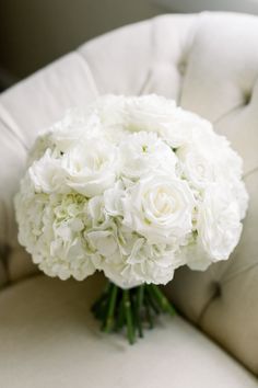 a bouquet of white flowers sitting on top of a chair