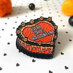 an orange and black pin sitting on top of a white table next to some fruit