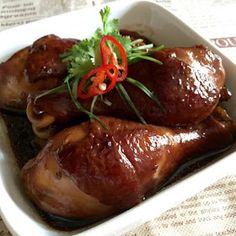 two pieces of meat in a white dish on a table