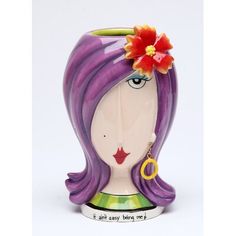 a ceramic figurine with purple hair and flower in it's hair is shown