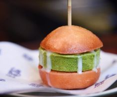 a green and white sandwich with toothpicks sticking out of it's bun