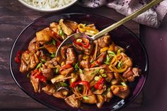 a purple plate topped with meat and veggies next to a bowl of rice