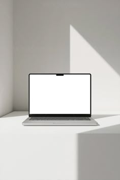 an open laptop computer sitting on top of a white shelf in a room with sunlight streaming through the window