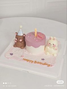 there is a birthday cake with two bears on the top and one bear sitting next to it