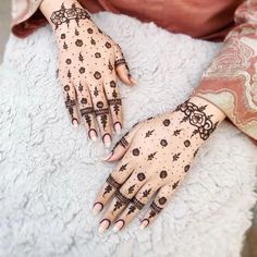 two hands with henna tattoos on them