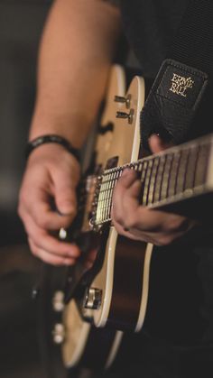 a close up of a person playing an electric guitar with a bible in the background